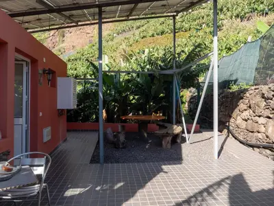 a patio with a table and some plants at Casa dos Anjos in Ponta do Sol