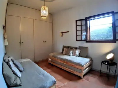 a bedroom with two beds and a window at Beach Tree House in Porto Santo