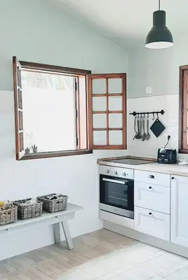 a kitchen with a stove and a window at Beach Tree House in Porto Santo