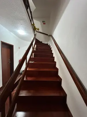 a staircase in a building with brown wooden stairs at Palmar Rooms in Funchal