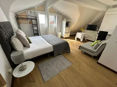 a bedroom with a bed and a living room at Palmar Rooms in Funchal