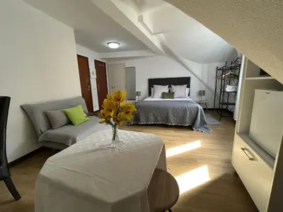 a bedroom with a bed and a table with a vase of flowers at Palmar Rooms in Funchal