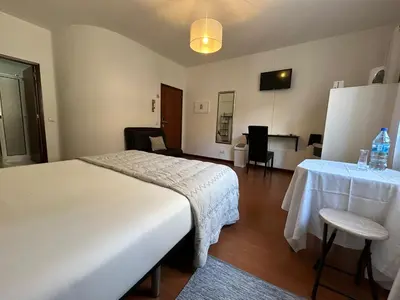 a hotel room with a bed and a table and chairs at Palmar Rooms in Funchal