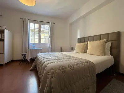 a bedroom with a large bed and a window at Palmar Rooms in Funchal