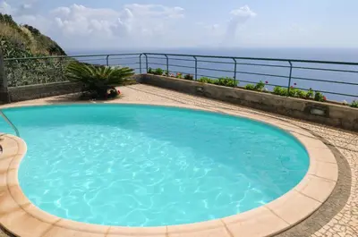 a swimming pool with the ocean in the background at Vivenda Belo Horizonte in Caniço