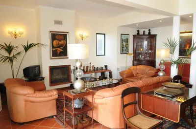 a living room with leather furniture and a table at Vivenda Belo Horizonte in Caniço