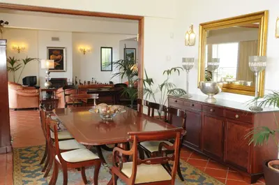a dining room with a table and a mirror at Vivenda Belo Horizonte in Caniço