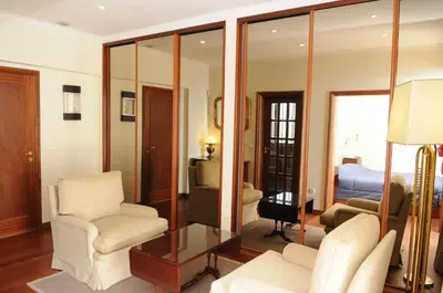 a living room with a room with a bed and mirrors at Vivenda Belo Horizonte in Caniço