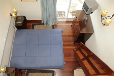 a living room with a blue couch and a television at Vivenda Belo Horizonte in Caniço