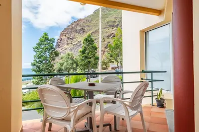 a balcony with a table and chairs and a view of the ocean at Magical Sunset in Madalena do Mar