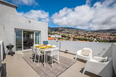 a balcony with a table and chairs and a view at Rooftop Funchal - By Wehost in Funchal