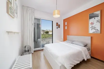 a bedroom with a white bed and an orange wall at Rooftop Funchal - By Wehost in Funchal