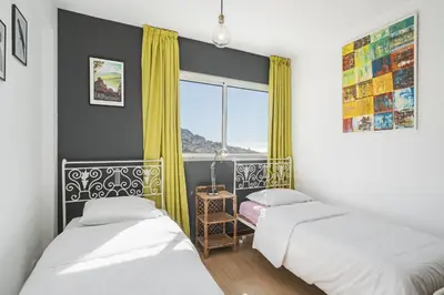 two beds in a small room with a window at Rooftop Funchal - By Wehost in Funchal