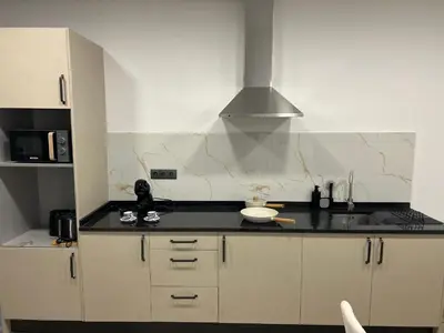 a kitchen with white cabinets and a black counter top at Victoria 1942 in Funchal