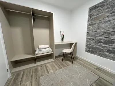 a room with a desk and a chair and a stone wall at Victoria 1942 in Funchal