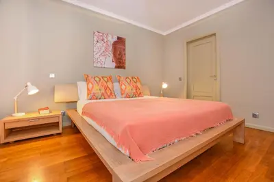 a bedroom with a large bed with orange comforter at Apartamento Costa Do Sol in Funchal