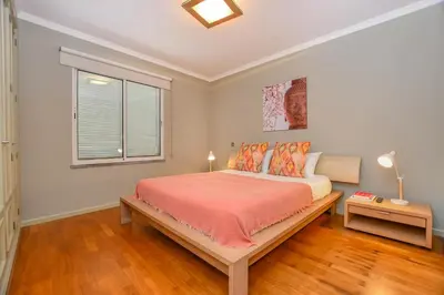 a bedroom with a bed with orange sheets and a window at Apartamento Costa Do Sol in Funchal