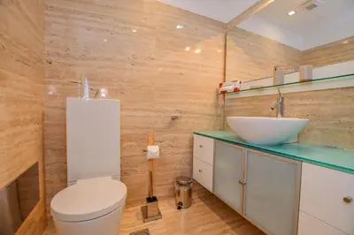a bathroom with a white toilet and a sink at Apartamento Costa Do Sol in Funchal