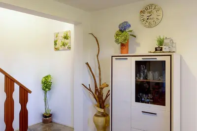 a room with a white cabinet and a clock on the wall at Recanto das Florenças (1) in Arco da Calheta