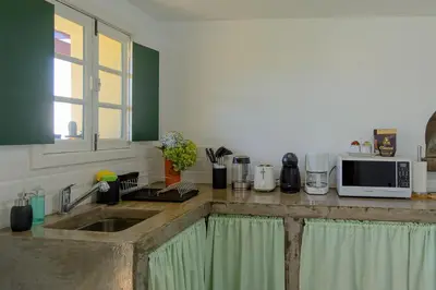 a kitchen with a sink and a microwave at Recanto das Florenças (1) in Arco da Calheta