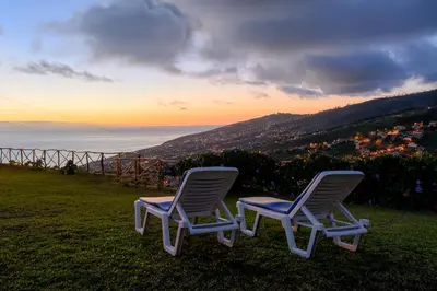two chairs sitting on a hill with a view of the ocean at Recanto das Florenças (1) in Arco da Calheta