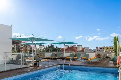 a row of tables and chairs with umbrellas on a deck at Hotel Madeira in Funchal