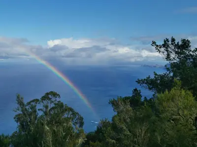 a rainbow over a body of water with trees at Santana in Nature Bed & Breakfast in Santana