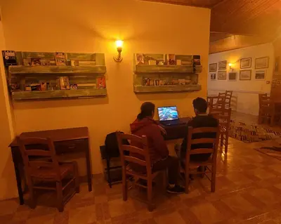 two people sitting at a table with a laptop at Santana in Nature Bed & Breakfast in Santana