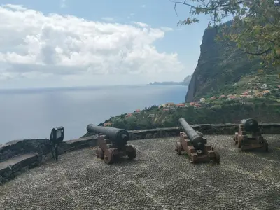 three cannons sitting on a wall near the water at Santana in Nature Bed & Breakfast in Santana