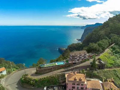 a train traveling down a road next to the ocean at Santana in Nature Bed & Breakfast in Santana