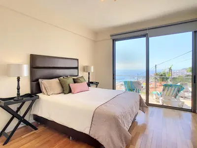 a bedroom with a bed with a view of the ocean at Villa Moniz by LovelyStay in Funchal