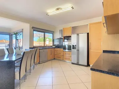 a kitchen with a refrigerator and a table with chairs at Villa Moniz by LovelyStay in Funchal