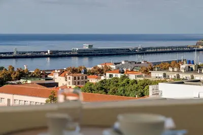 a view of a city with the ocean and a pier at Alegria I by An Island Apart in Funchal
