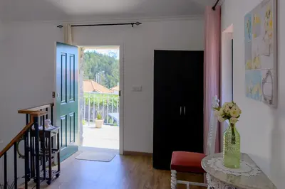 a living room with a vase of flowers on a table at Recanto das Florenças (2) in Arco da Calheta