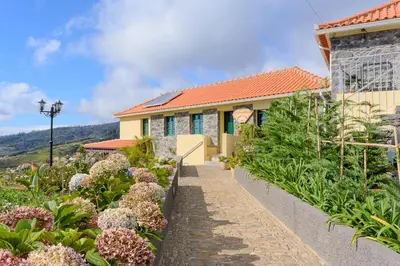 a house with a garden in front of it at Recanto das Florenças (2) in Arco da Calheta