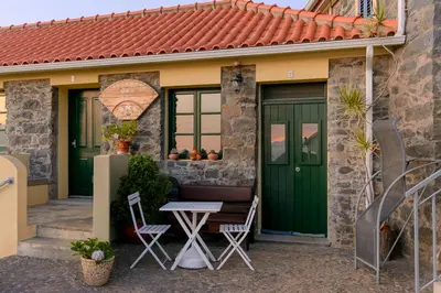 a house with a green door and a table at Recanto das Florenças (2) in Arco da Calheta