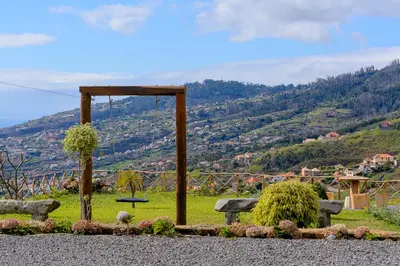 a park with benches and a view of a mountain at Recanto das Florenças (2) in Arco da Calheta