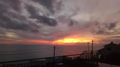 a sunset over the ocean with a cloudy sky at Casa Raivinha in Arco da Calheta