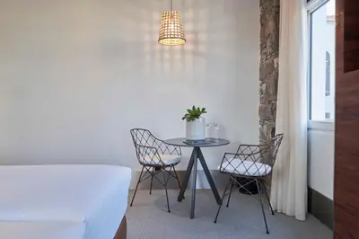 a table with chairs and a potted plant on it at Hotel Cajú in Funchal