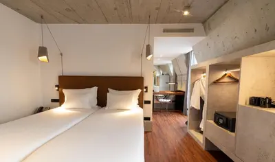 a bedroom with a large bed with white pillows at Hotel Cajú in Funchal