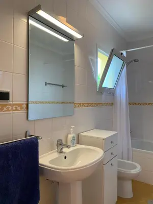 a bathroom with a sink and a mirror and a toilet at Cozy Apartment in Porto Santo