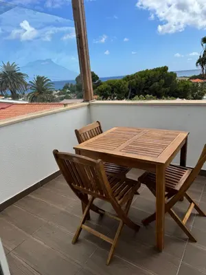 a wooden table and two chairs on a balcony at Cozy Apartment in Porto Santo