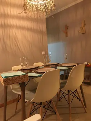 a dining room table with chairs and a chandelier at Cozy Apartment in Porto Santo