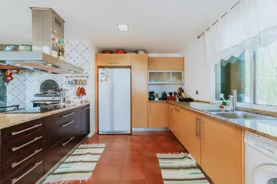 a kitchen with wooden cabinets and a white refrigerator at Villa Sol by Amazing Madeira in Ponta do Sol