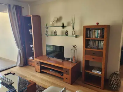 a living room with a television and a book shelf at GuestReady - Vila Formosa in Funchal