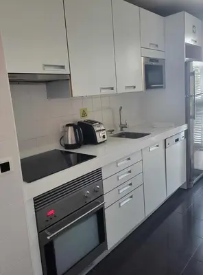 a kitchen with white cabinets and a stove top oven at GuestReady - Vila Formosa in Funchal