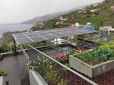 a rooftop garden with a solar panel and flowers at Casa Atlantico Dachterrassengeschoss in Ribeira Brava