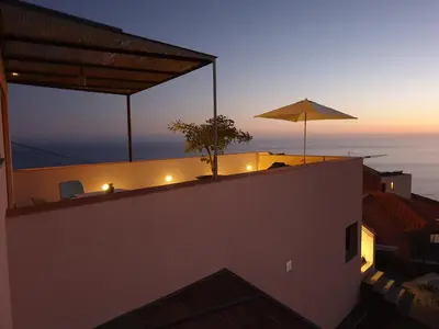 a balcony with an umbrella on top of a building at Casa Atlantico Dachterrassengeschoss in Ribeira Brava