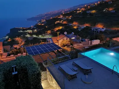 a house with a swimming pool and a solar array at Casa Atlantico tropischer Seitenflügel in Ribeira Brava