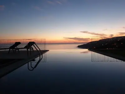 a couple of chairs sitting next to a body of water at Casa Atlantico tropischer Seitenflügel in Ribeira Brava